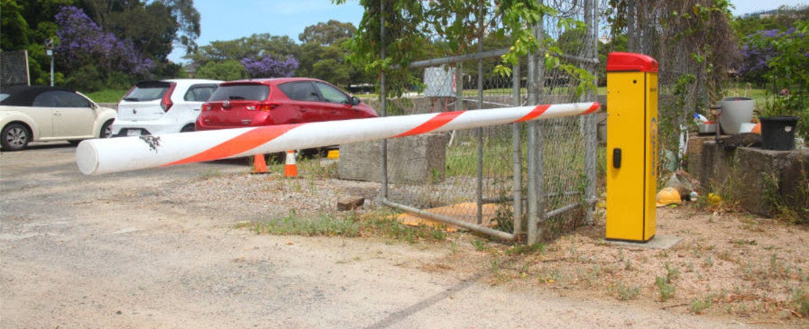 Close-up of a sector boom gate arm at the entry of a car park.