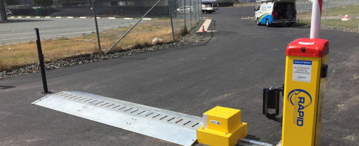 High-security airport car park with a boom gate and tiger spikes.