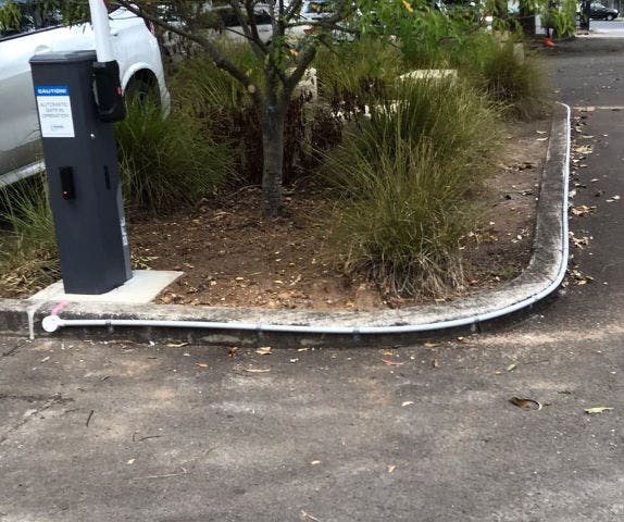 Close-up of electrical ducting work fixed a long-bending landscape curb.