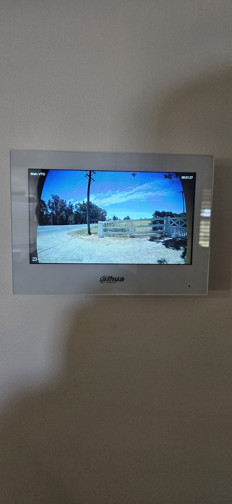 Video intercom monitor showing a gate camera feed.