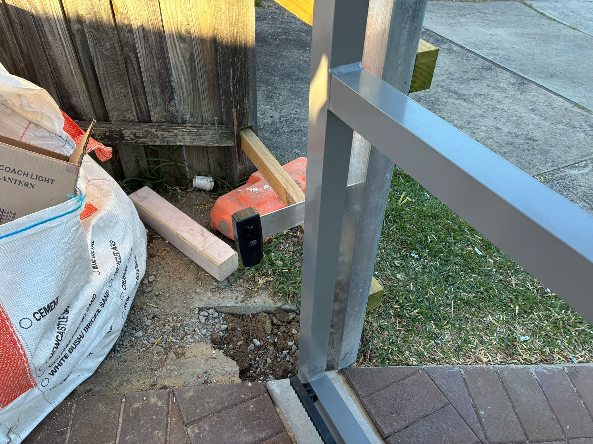 Safety sensor installed beside a residential sliding-gate driveway