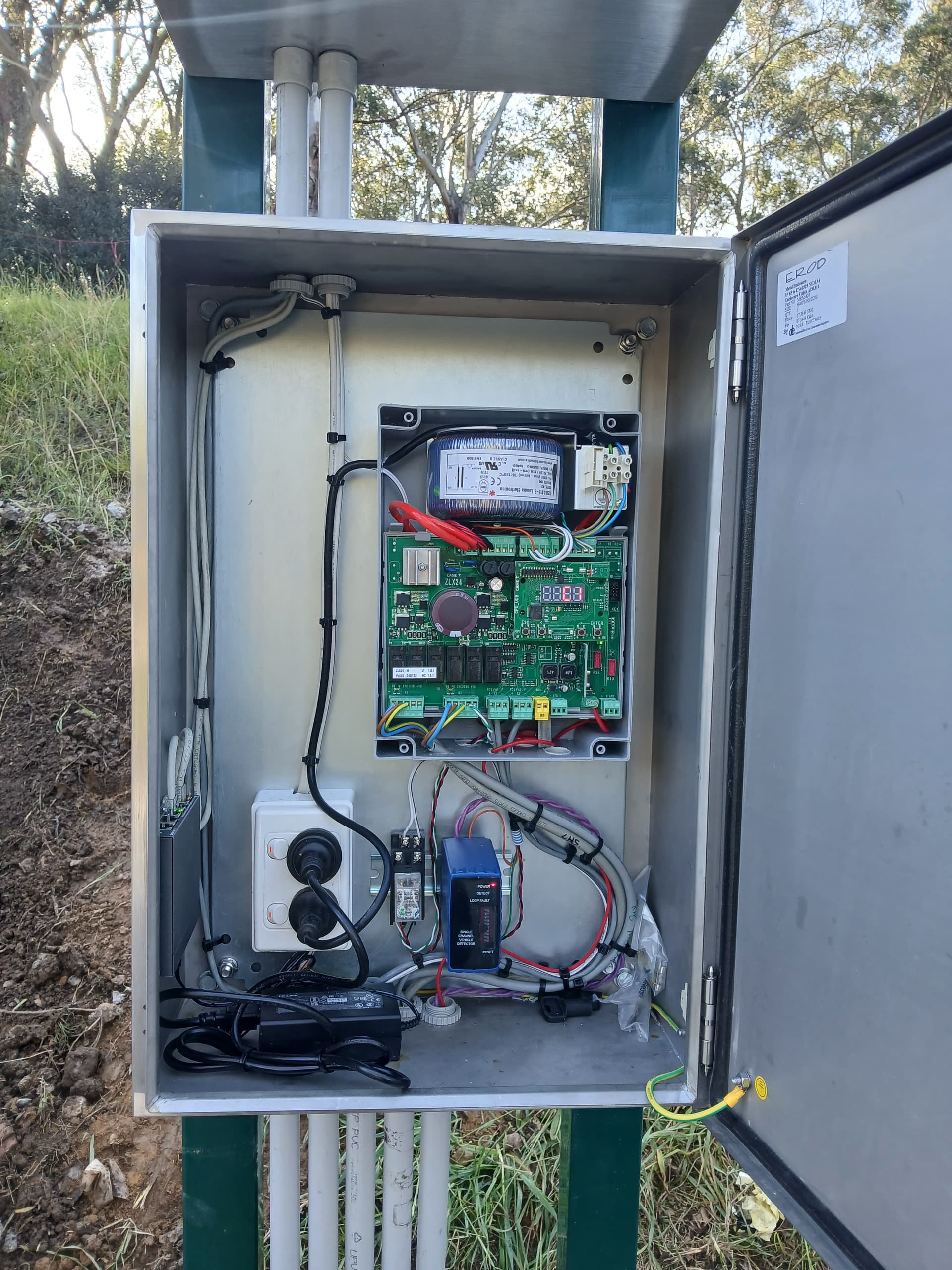 Open automatic-gate control enclosure showing the controller and field wiring