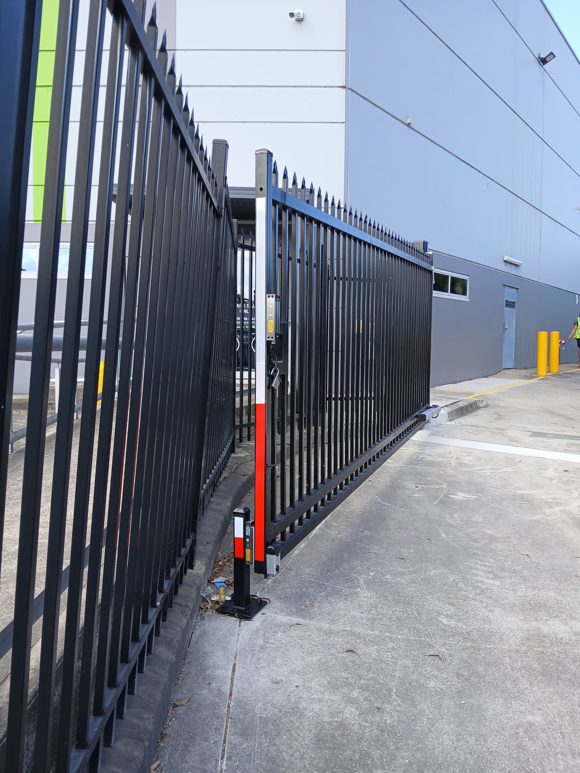 Black automated double gates across a commercial driveway
