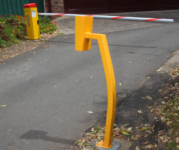 Close-up of a boom gate and intercom system at the entry of a car park.