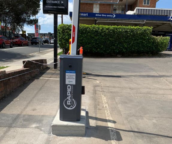 Side view of a high-traffic volume boom gate for a hotel car park.