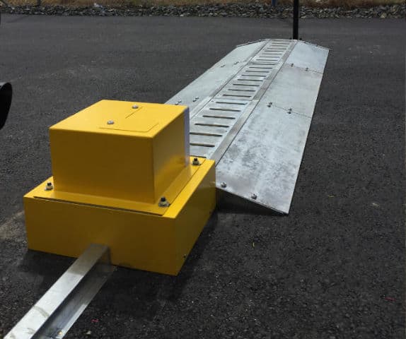 Close-up of high-security airport car park boom gate tiger spikes.