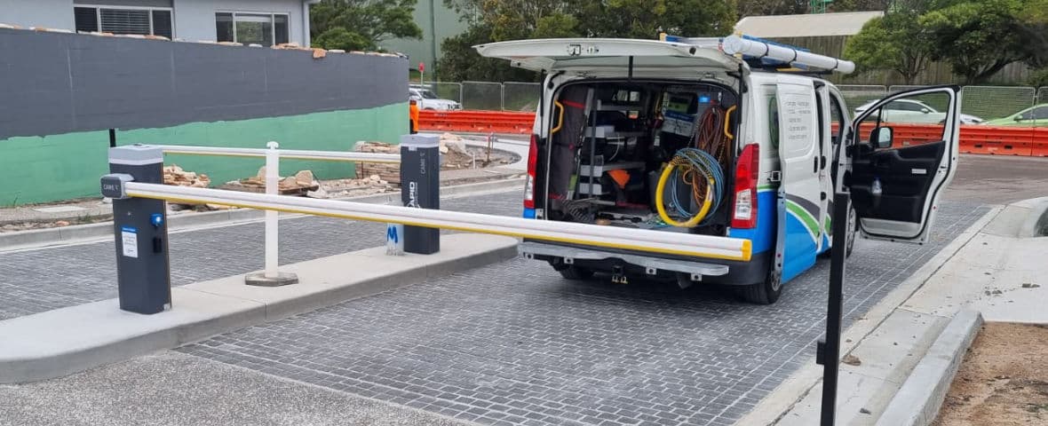Rapid Automatic technician's vehicle parked in front of a double adjoining boom gates at the entry/exit of a retirement village.