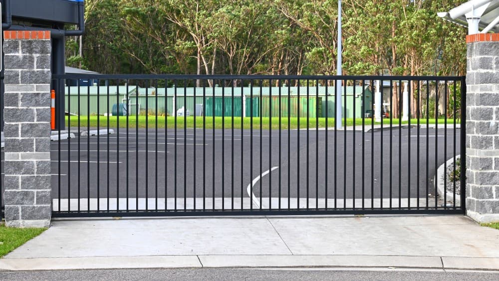 Heavy-duty black sliding gate installed at a commercial property entrance.