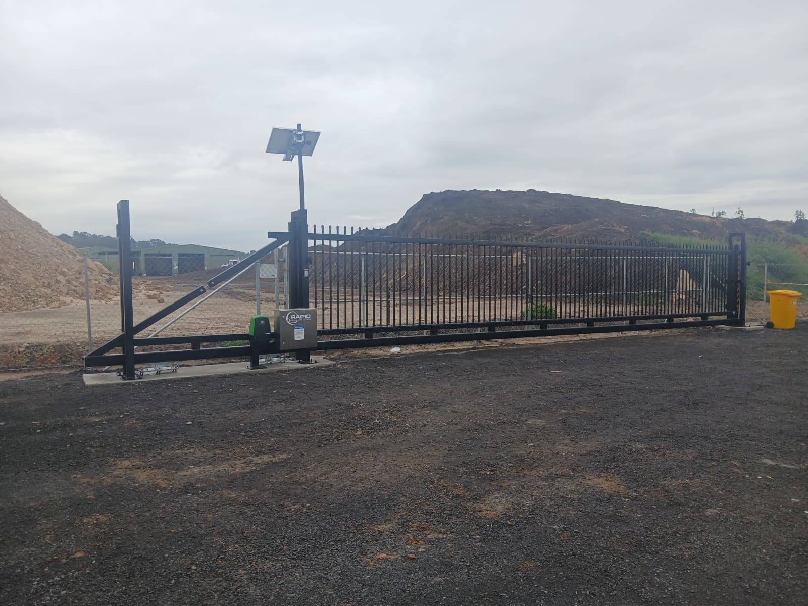 Black solar powered sliding gate installed by Rapid at an earthworks yard.