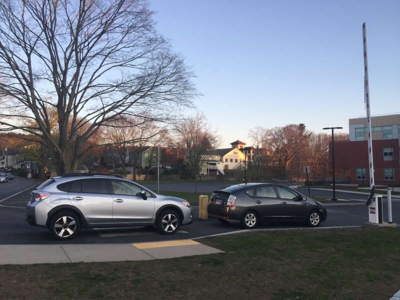 Two vehicles queued at an automatic boom-gate lane