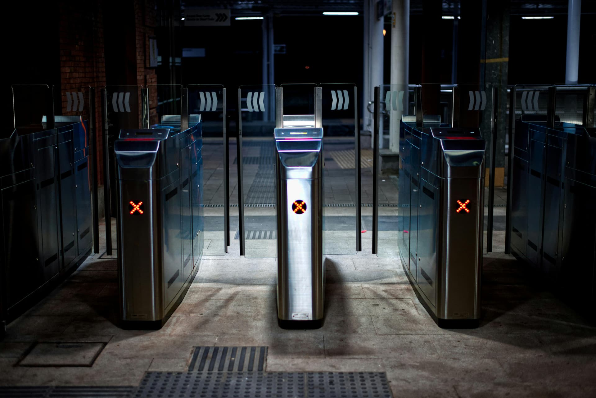 Two commuters passing through waist-height subway turnstiles