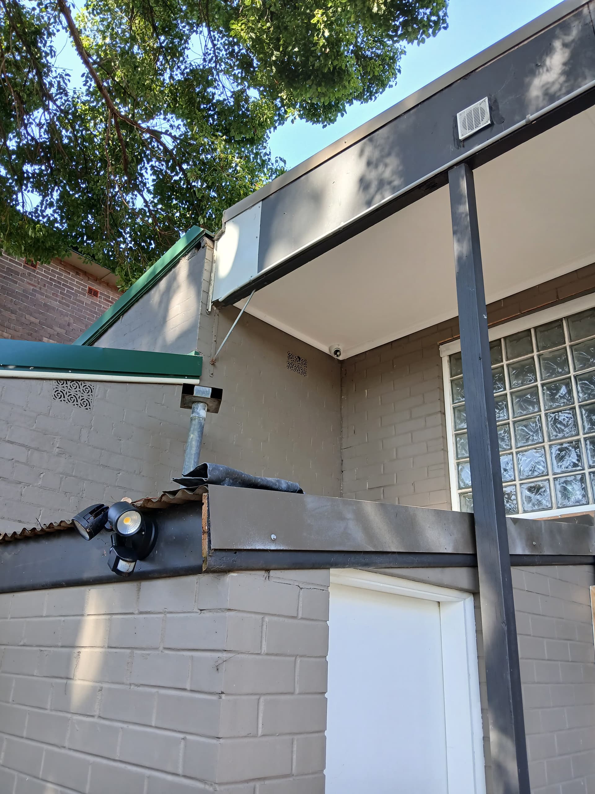 CCTV camera and floodlight above an external doorway.