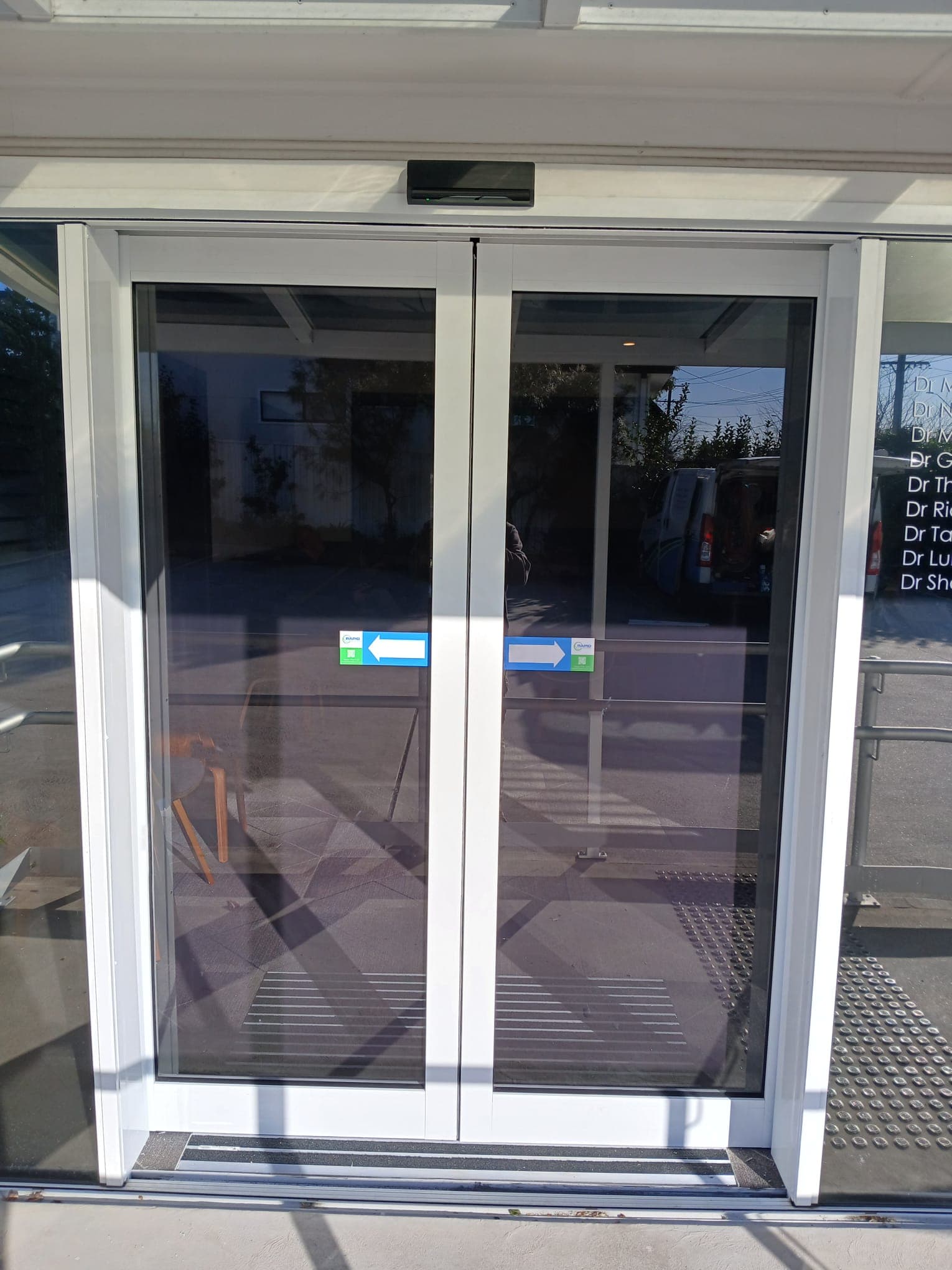 Automatic sliding glass doors at a controlled pedestrian entrance.