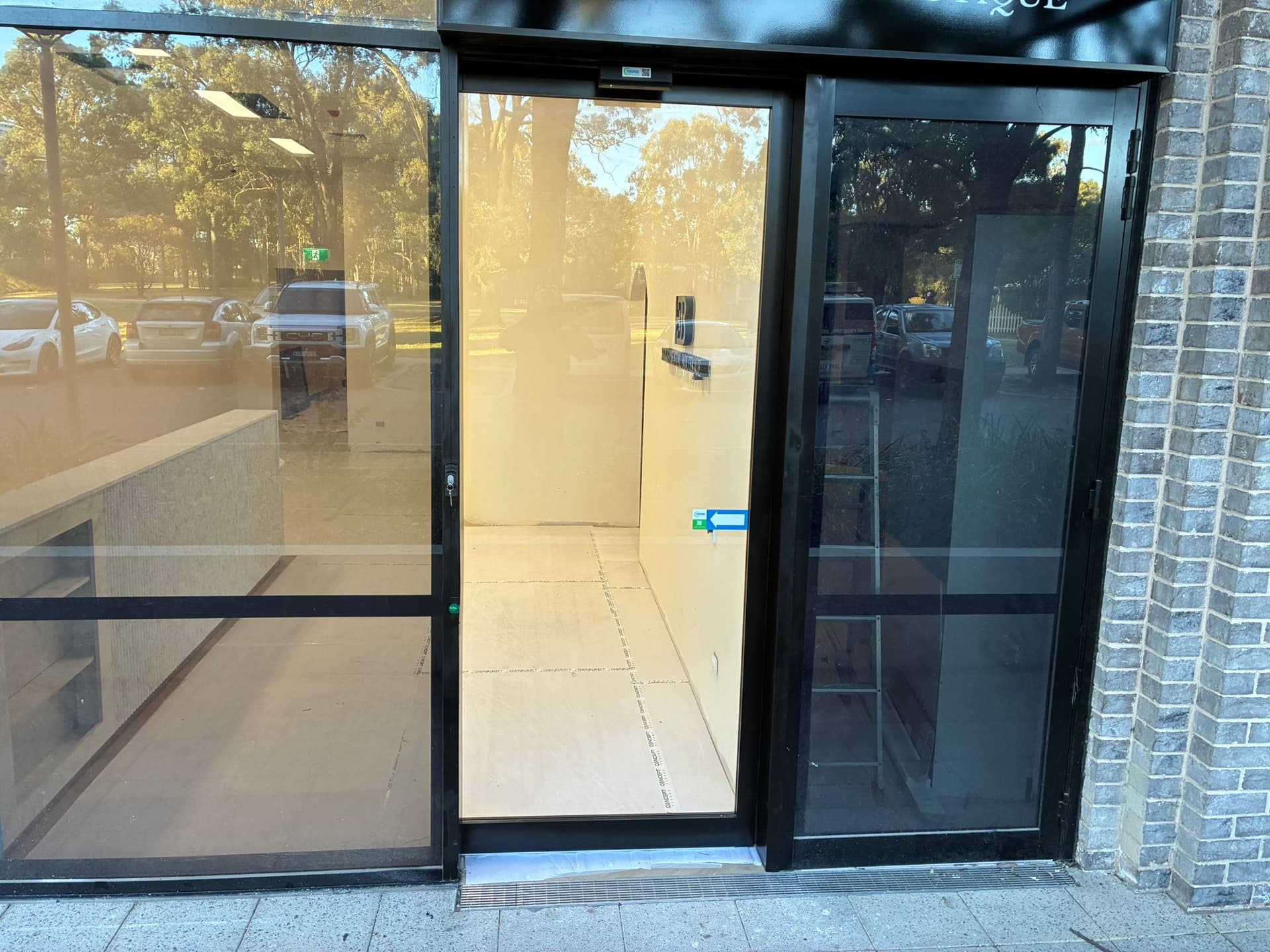 Black-framed automatic sliding glass entrance at a commercial building