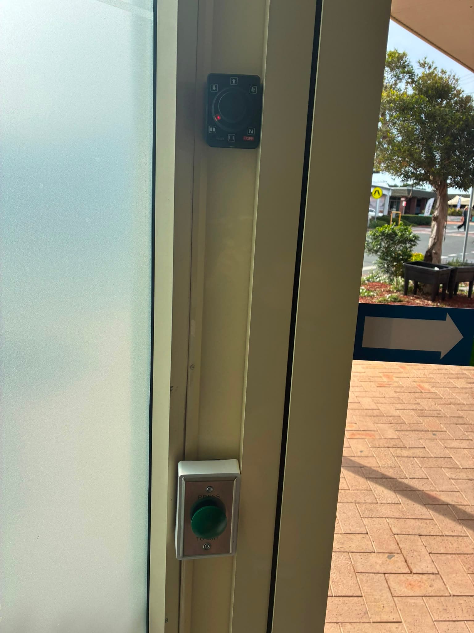 Access-control reader and exit button installed beside an automatic library door