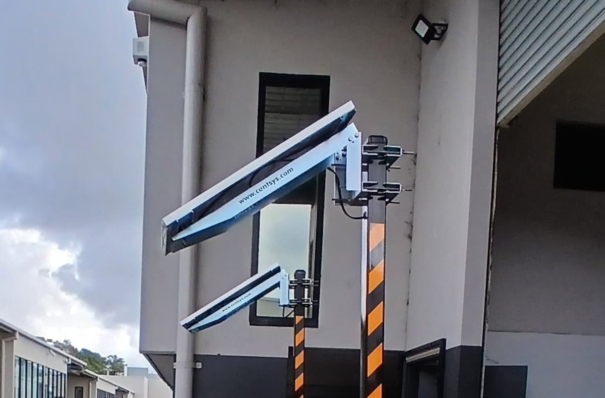 Solar panels mounted above an automatic access operator at a commercial entry.