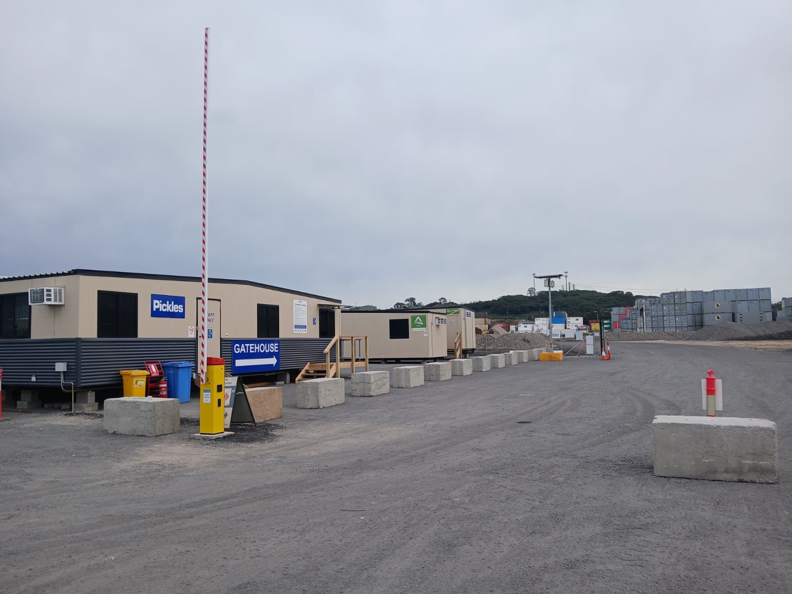 Raised Rapid boom gate beside portable site offices at an industrial yard