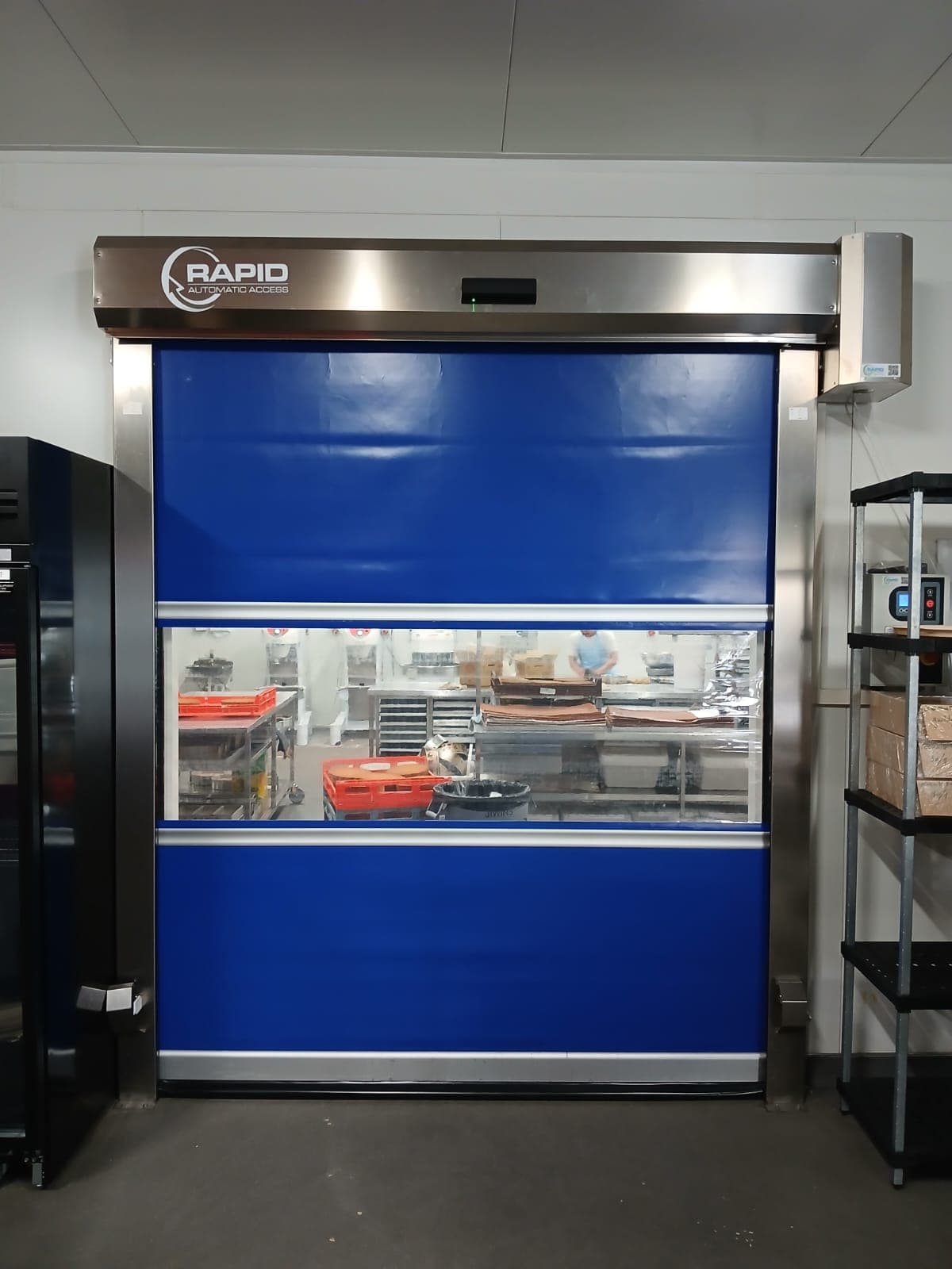 Blue high-speed door installed in a food preparation area.