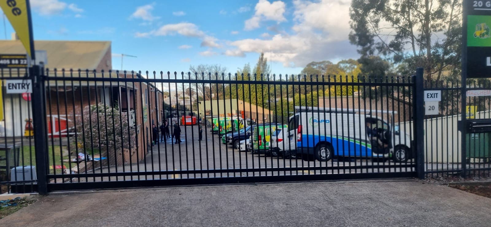 Automatic sliding gate opener system at a commercial driveway entrance.