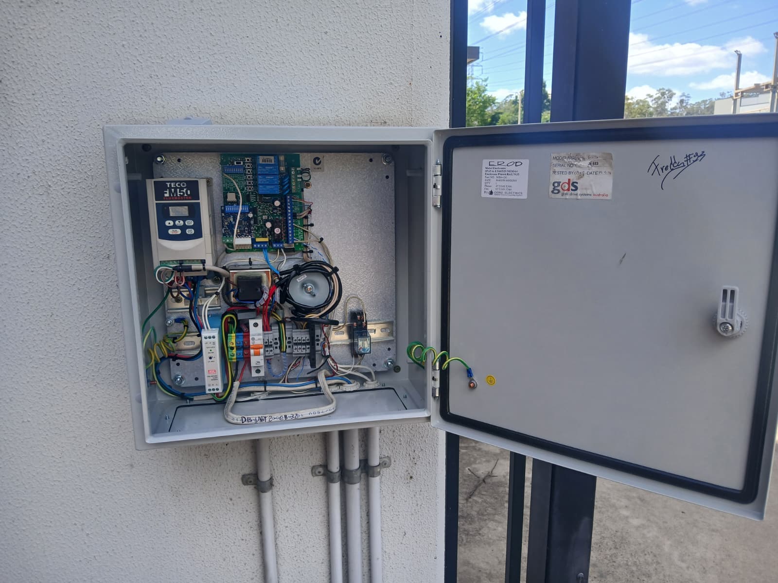Open automatic gate control cabinet showing wiring and control components during fault diagnosis.