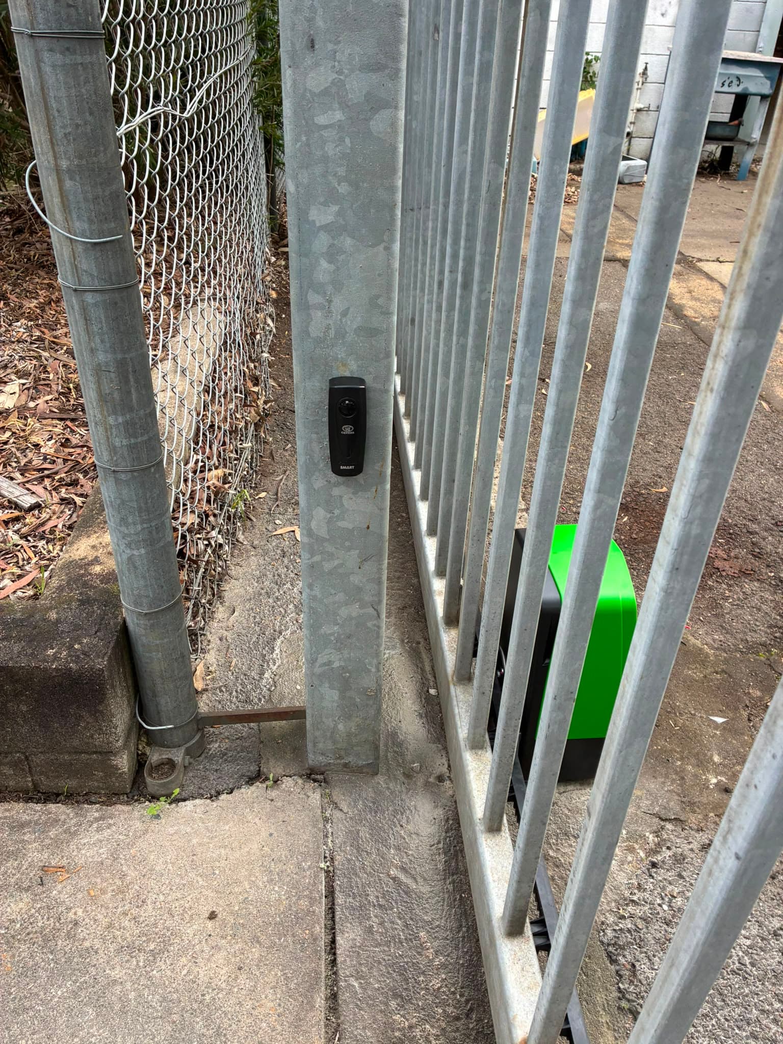 Safety sensor mounted beside a galvanised industrial sliding gate