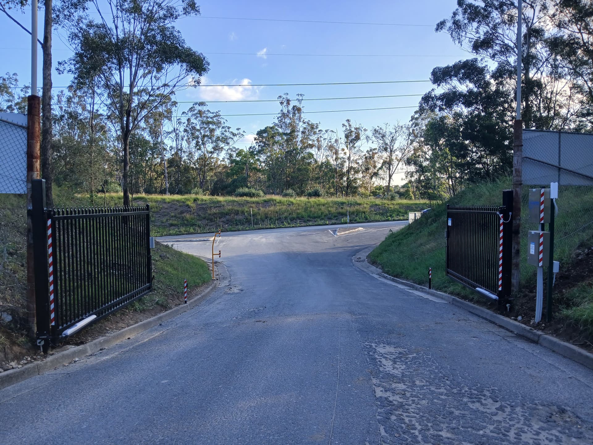 Double swing driveway gates at a landscaped property.
