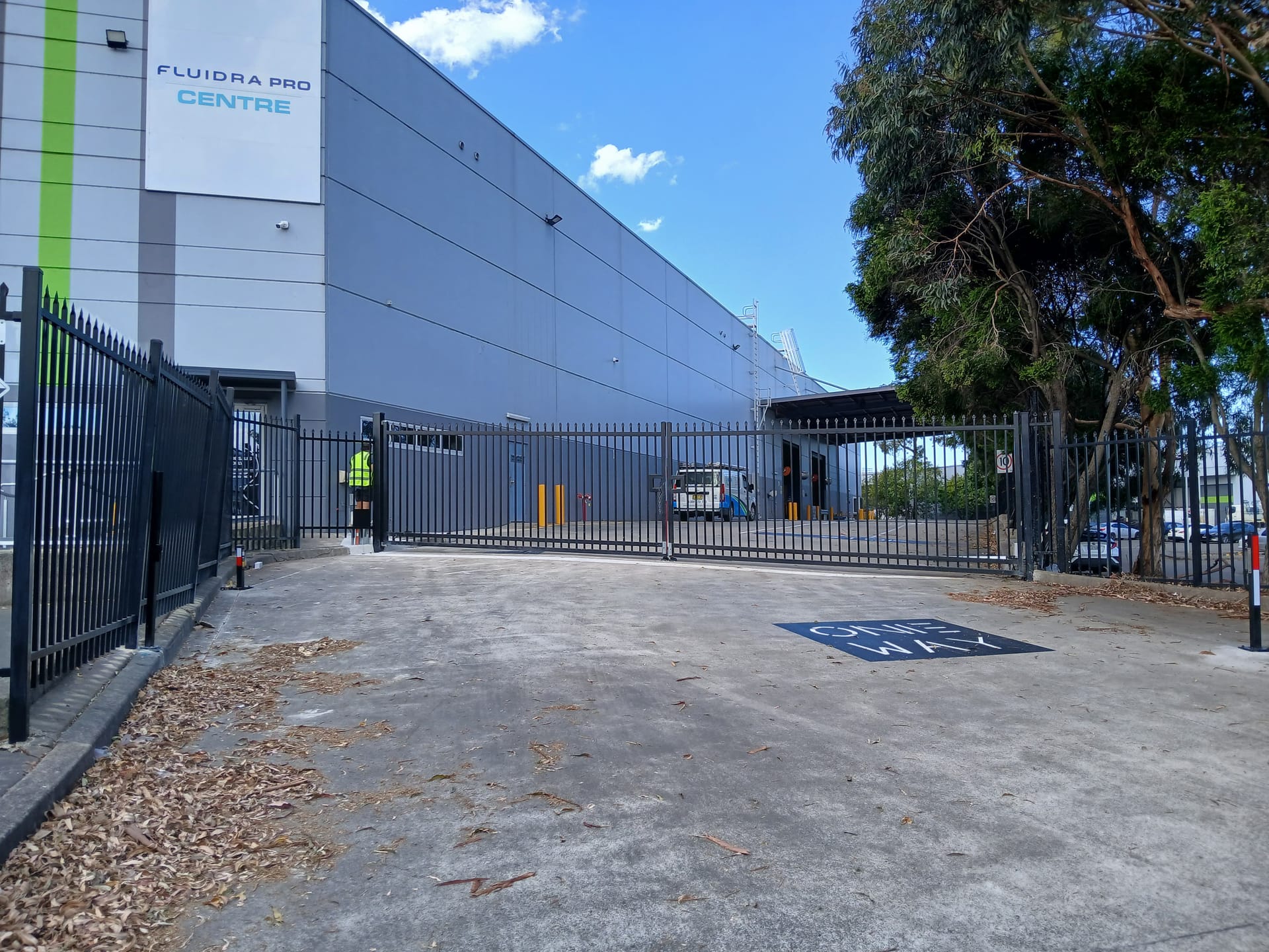 Black double commercial gates at a business facility entrance.