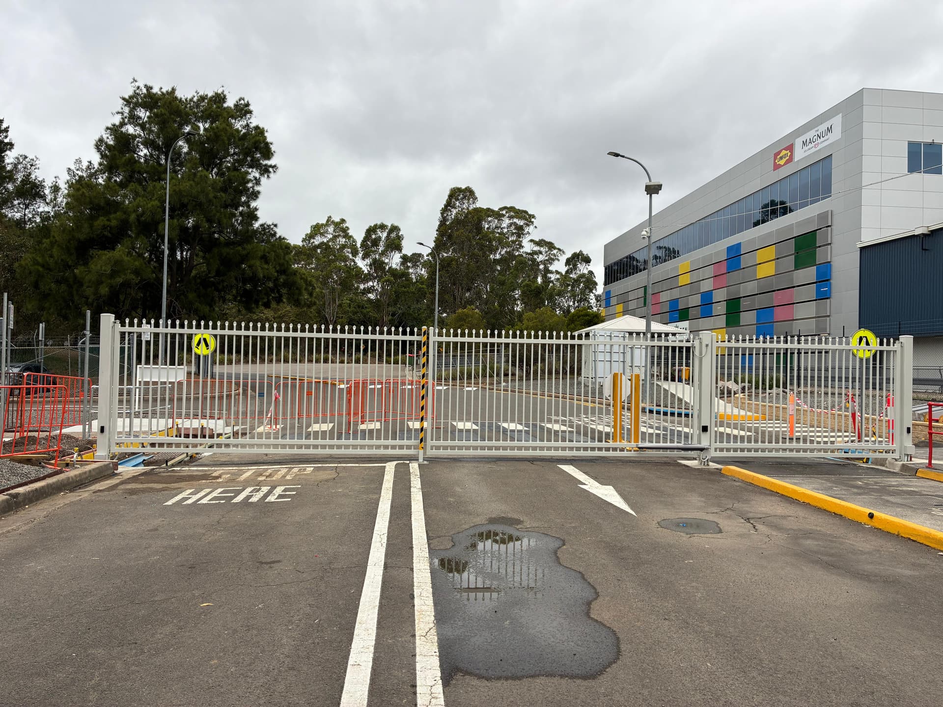 White double swing gates across a marked industrial driveway
