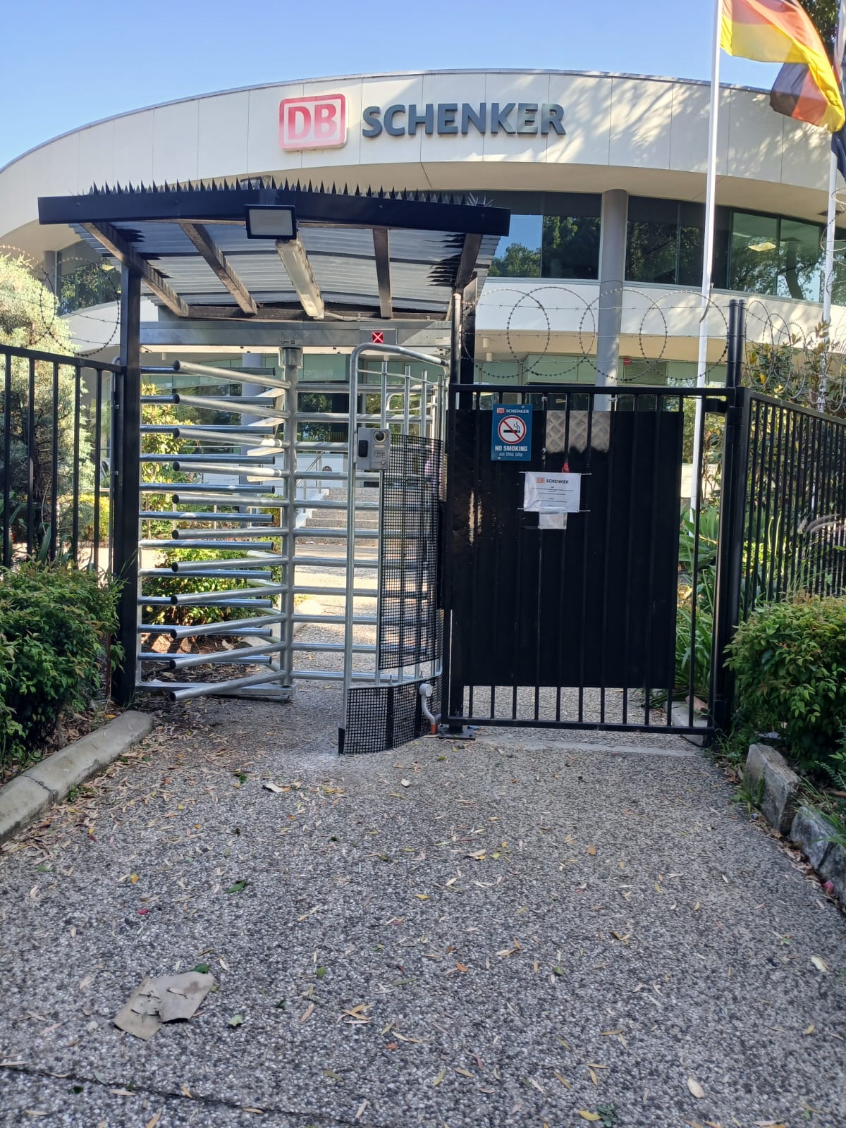 Full-height turnstile and pedestrian gate at a commercial site entrance.
