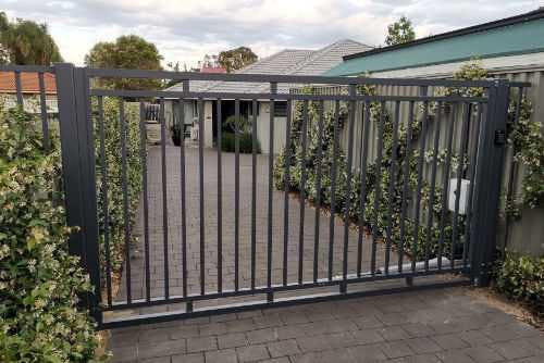 A driveway and single swing gate at a residential home.
